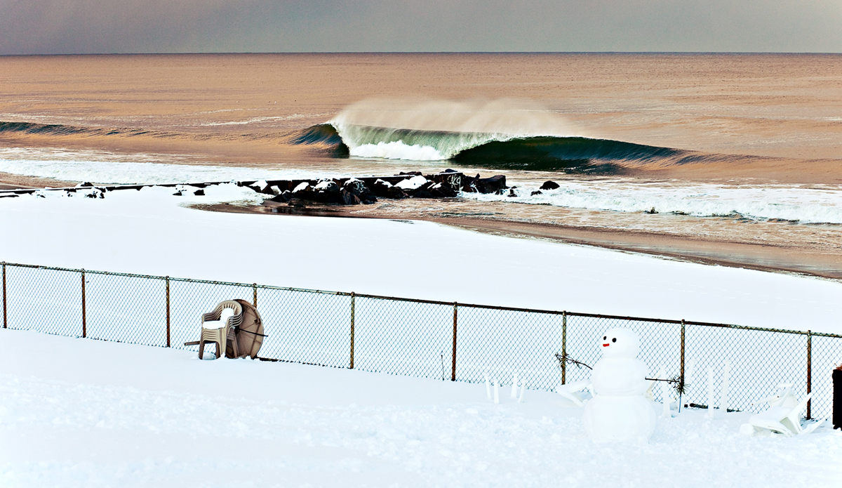 A cold winter day just after a passing snow storm laid a pile of fresh snow and brought plenty of waves to New Jersey. I was shooting water this day and came away with a few good images but I knew I had to get out and get the land angle with the snowman. I saw a child making it as we paddled out. This is one of my best selling prints and you can purchase it <a href=\"https://greatbreaks.surfline.com/collections/all/products/frosty-the-stoke-man\">here</a>. Photo: <a href=\"https://www.ryanstruck.com/\"> Ryan Struck</a>