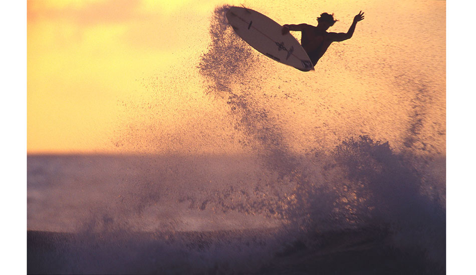 This was maybe 1999, and it was super late in the day. Heaps of photog\'s had packed up and left for the day, and there were only a few left on the beach at Off The Wall. I saw the golden light starting to build in the sky, so I headed down towards Backdoor on the off chance that if Bruce busted an air, he might do it against this one golden bit of sky, thus at least giving me a backlit silhouette of him. Sure enough, Bruce goes huge, and I took about six slides of it at at about a 40th or a second. Here\'s the amazing bit: during just that moment of inertia at the height of his maneuver, he was still enough for me to produce a reasonably sharp image. None of the others were anywhere near as good. Photo: <a href=\"https://seandavey.com//\" target=_blank>Sean Davey</a>