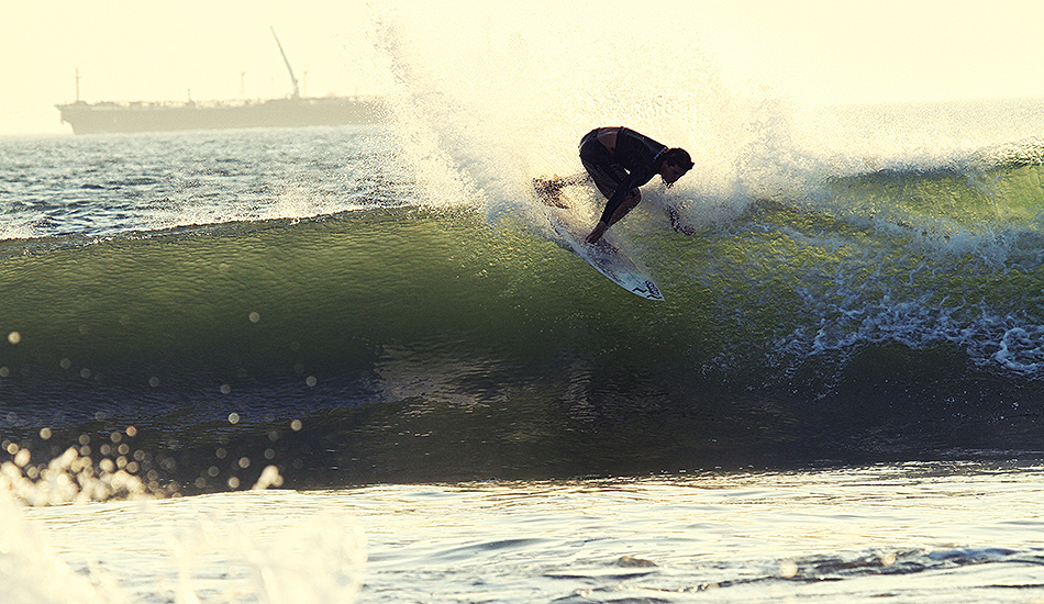 A few days the wind stayed offshore or light enough to get a fun evening session in.  Unidentified Brazilian getting a good right on the left point out front. Photo: Greg Heine 