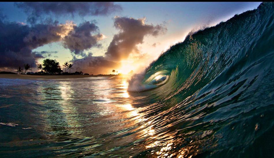 Sunrise in the background lighting the wave up nicely from the front.  Image: <a href=\"https://gokenji.com/port/\" target=\"_blank\">Croman</a>