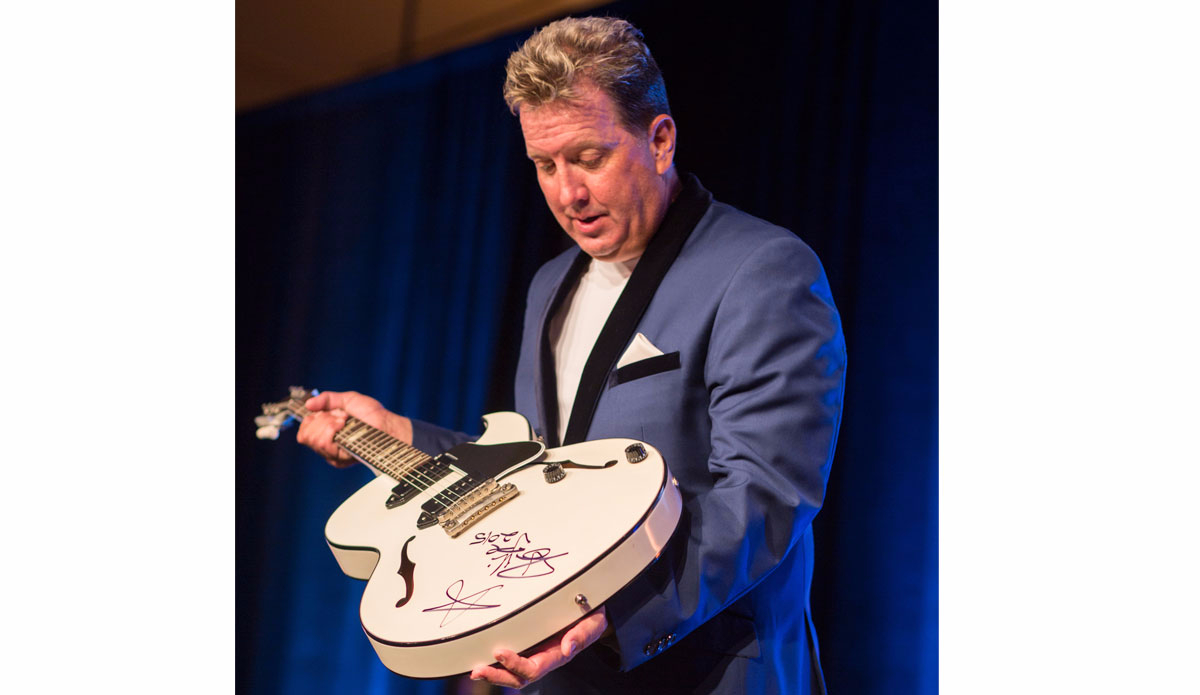 Auctioneer Shawn Parr with an autographed guitar from Billie Joe Armstrong\'s private collection that sold for more than $17,000 at Pipeline to a Cure. Photo: Cystic Fibrosis Foundation
