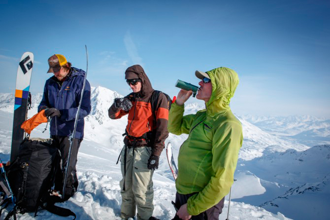 The crew enjoys some refreshments on the summit of cracked ice. The peaks in the background are what locals affectionately refer to as the “far-far gnar-gnar”. Photo: Spencer James