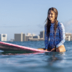 woman wearing a rashguard on a surf board
