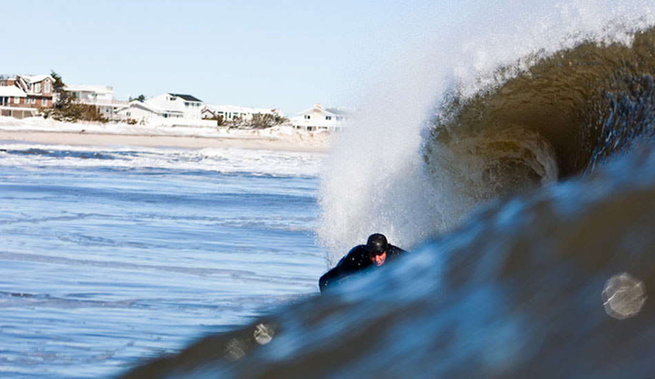 The sand was frozen solid on the beach this day. Water temperature: 38. Air temperature: 17. Brian Parnagian outside on a cold day in the sun.