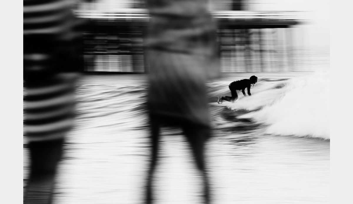I don’t think this photograph would work without the people standing in the foreground. It seems like the surfer is putting on a show for all to watch. Photo: <a href=\"https://www.facebook.com/chrisdelorenzophotography\">Chris DeLorenzo</a>
