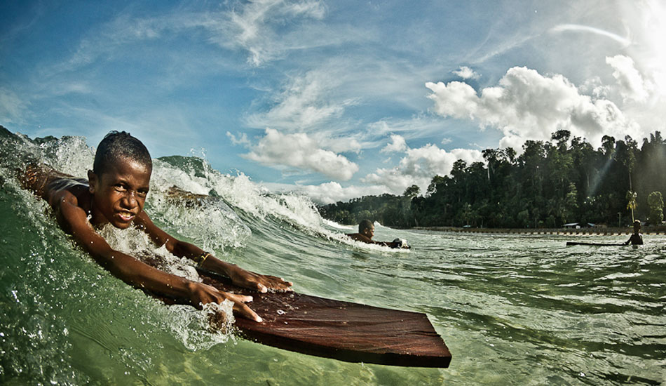 This was a little mission I did with Mikala and Dede to chase a swell. But durning a quick break from surfing I swam out and shot with the local kids while they were riding these planks of wood. This shot ended up being the cover on Transworld Surf travel issue. I\\\'m looking forward to this year when I go back there and show this grom his photo on the cover. Photo: Brad Masters