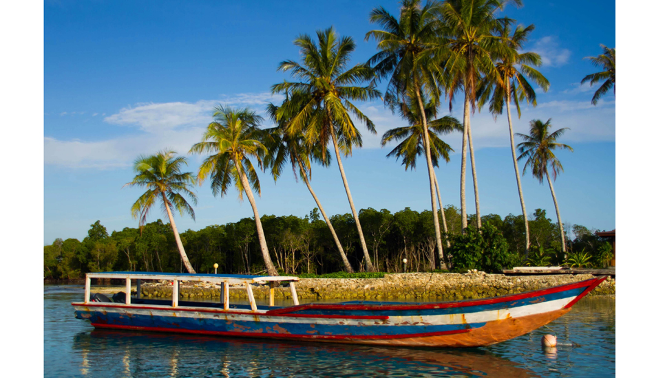 Macaroni\'s long boat, sitting quietly in the lagoon in front of the resort. Photo: <a href=\"https://www.andypotts.com.au\" target=\"_blank\">www.andypotts.com.au</a>