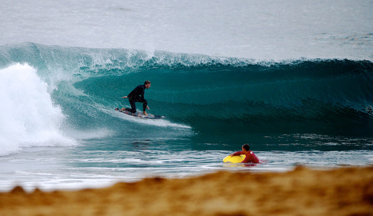 Clay Crandal pulls into a hollow barrel close to shore at dawn. Photo: <a href=\"https://www.driftwoodfoto.com/\">Benjamin Ginsberg</a>