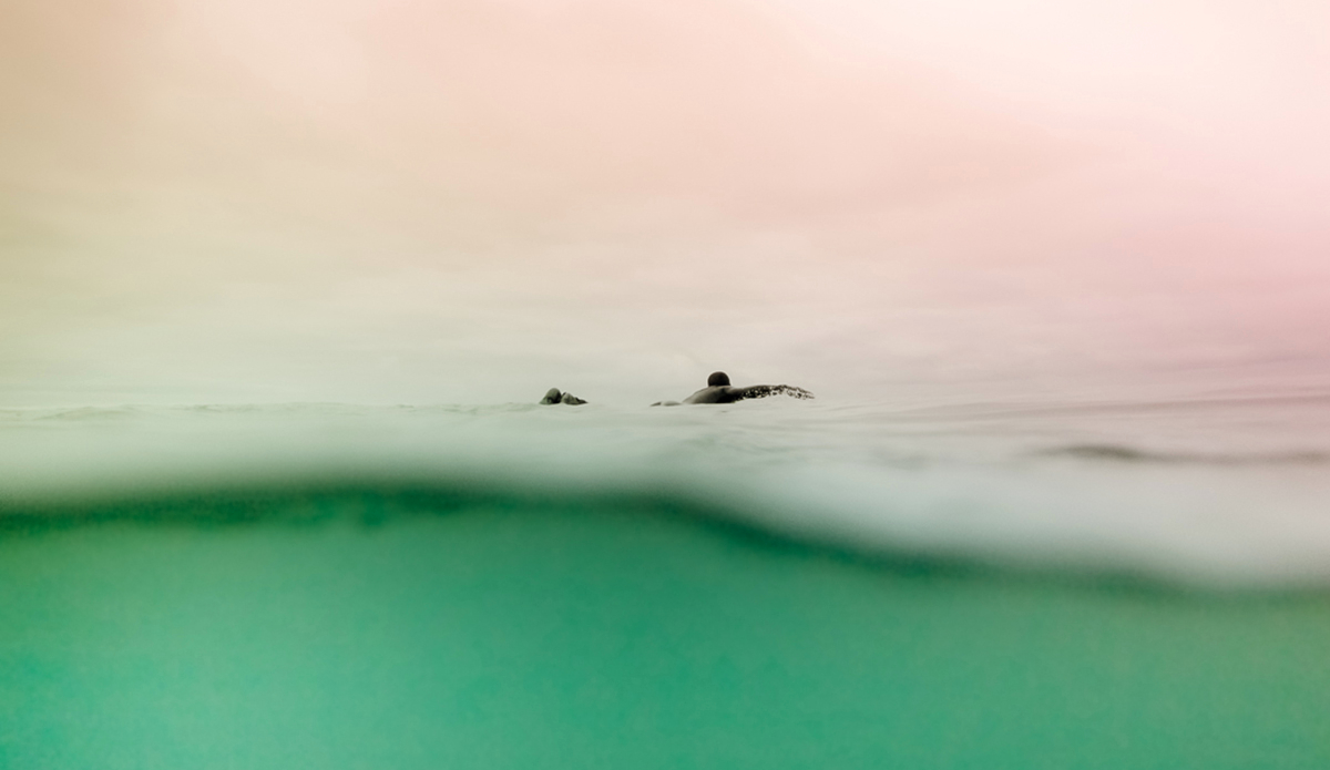 James Sayers paddling out to a secret surf spot on Southern Vancouver Island.  Vancouver Island, BC. Canada.