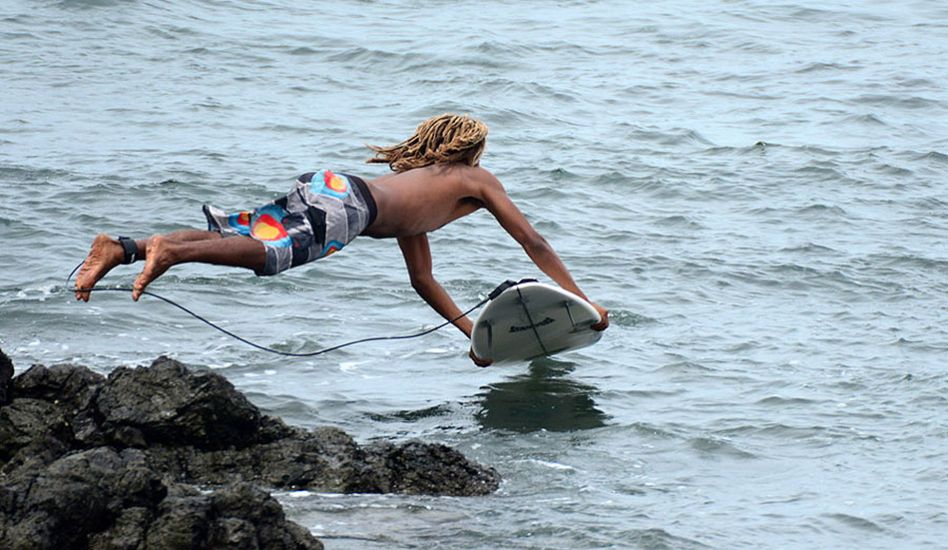 Gilbert Brown of Costa Rica jumps off the rocks to avoid the monster paddle out. Photo: <a href=\"https://www.isawsg.com/\" target=_blank>ISA/Michael Tweddle</a>.