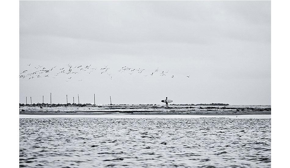 Morning Commute: 2011 Wrightsville Beach, NC. Local surfer contemplating his paddle across sharky waterway. On this day, it was worth the paddle. Photo: <a href=\"https://www.chrisfrickphotography.com/\" target=_blank>Chris Frick</a>.