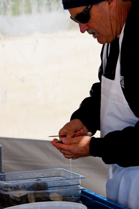 Bob Nugent, owner of the Black Whale restaurant, shucks clams for competitors and spectators to snack on. Bob is also a competitor in the annual event.