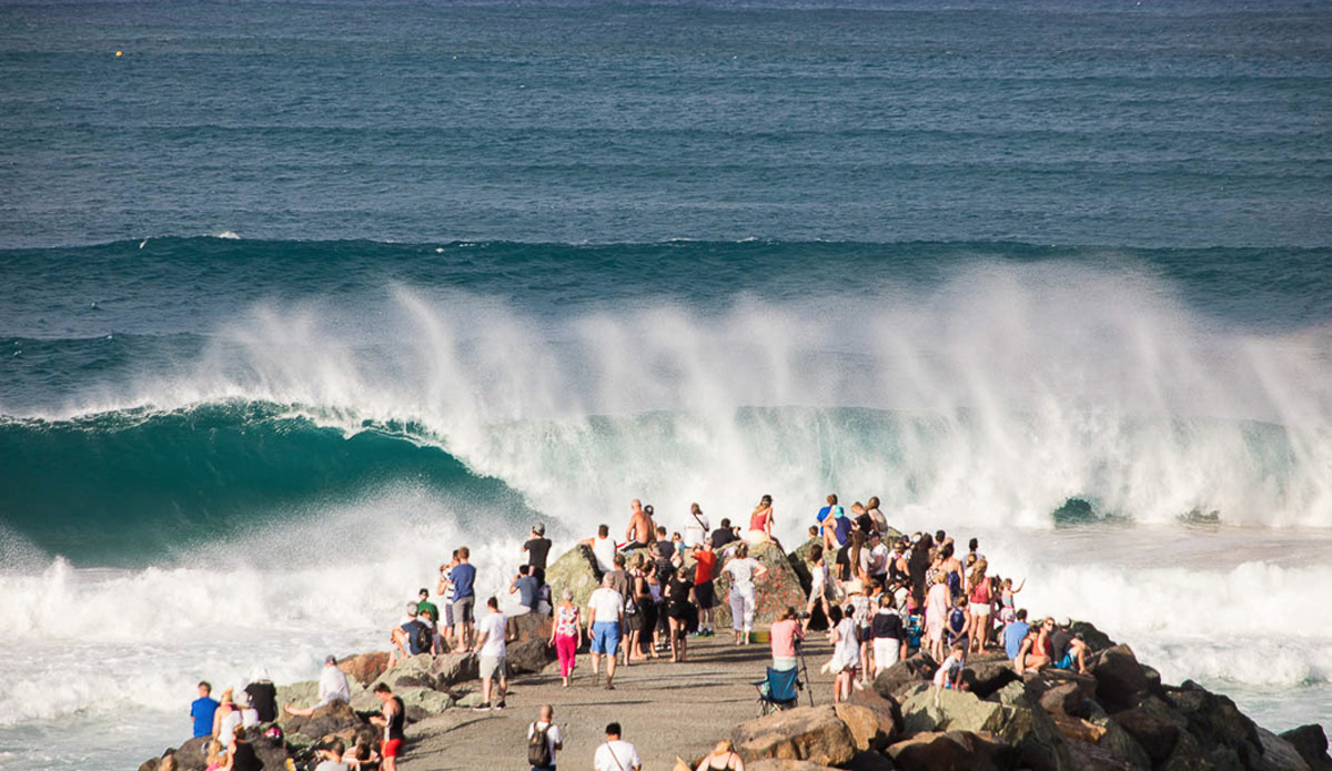 Spectators lining the shores watching the power of the waves.