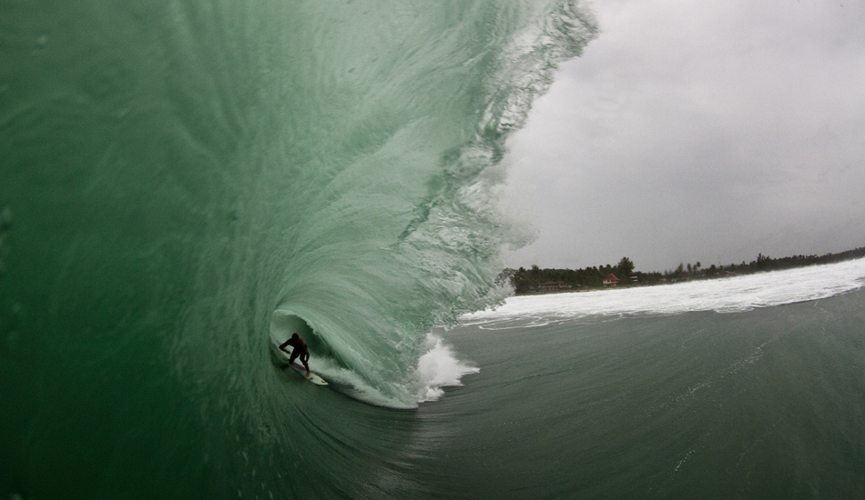 Dean Brady, Telos. Dean is a huge human, and at 6\'5\" needs a bit of wave to get going. He utilises his bulk well though, attacks thick, wedging barrels like this one with gusto. This is the same beachbreak as the Bruno Santos shot, and there is something so exotic about finding breaks like this in the middle of sharp coral reef zones. Image: <a href=\"https://www.sparkesphoto.com\" target=\"_blank\">Sparkes</a>
