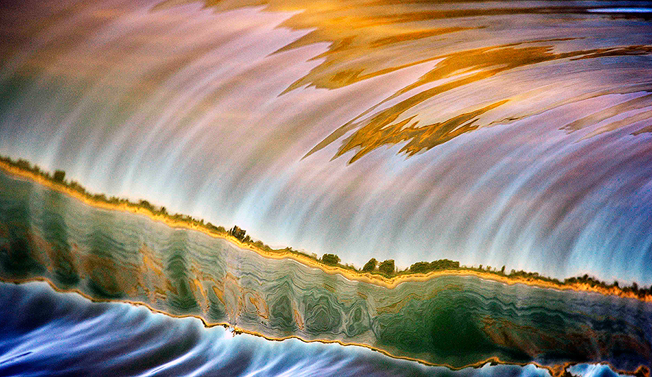 The glassy conditions this day played a big part in being able to capture the reflection of the shoreline in the wave. Photo: <a href=\"https://www.debmwaveart.webs.com/\" target=_blank>Deb Morris</a>.