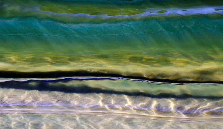 Looking through the face of a five centimeter wave. The reflection of the sun trickling through the wave resembles a snake\'s skin. Photo: <a href=\"https://www.debmwaveart.webs.com/\" target=_blank>Deb Morris</a>.
