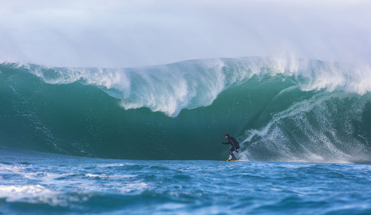 Tim Searing rides a giant wave at a remote reefbreak near Dunedin, New Zealand. Photo: Derek Morrison