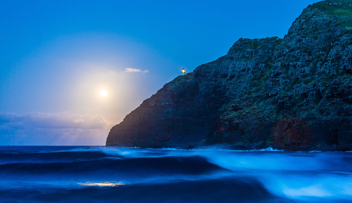 This image was captured on August 10th, 2014, on the windward side of the island. There was a slew of storms and large swells in the water. A few friends and I went over to body surf and catch a few waves. After returning to the parking lot from the water, we realized it was the super moon of 2014 and the moon was rising just after the sun was setting. I didn\'t have a tripod so I used my backpack to prop my camera up for a long exposure due to low light. I think it was around 2 seconds. A nice set came in giving me the opportunity to capture three waves peeling at one time. The glowing light isn\'t the sun, but the moon. I tried my best to keep this image as original as possible without much post processing. The glow of the moon was so strong it actually produced a lens flare. Photo: <a href=\"https://instagram.com/dougfalterphotography/\"> Doug Falter</a>