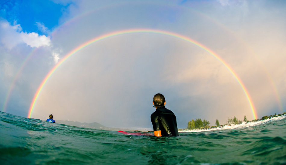Joe Guinand sitting in awe under the most ridiculous double rainbow spanning across the Bay. Image: <a href=\"https://www.alexfrings.com\" target=\"_blank\">Frings</a>