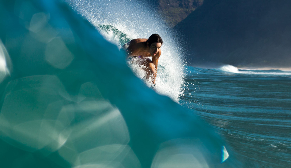 Kanoa Chung, son of shaper Terry Chung, in crystal blue Kauai water.
