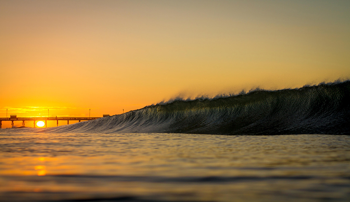 Sunrise sunshine peaking up from behind the Bogue Inlet Pier, this is the first morning we saw swell from Hurricane Bertha this Fall. Photo: <a href=\"https://www.surferphotos.com/\">Graham Hunt</a>