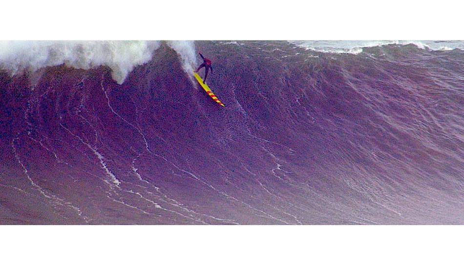 Keali\'i Mamala, Nazare, Portugal  2013. Very late afternoon of day three of the biggest day surfed at Nazare so  far. Keali\'i borrowed Garrett\'s 12\' Greg Noll gun, paddled two miles from  town and caught it. Photo: <a href=\"https://www.greghuglin.com\">Greg Huglin.</a>