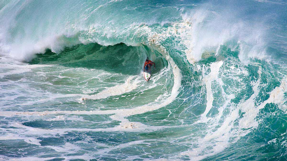 This one is Andy Irons during the Eddie way back when. I never met him but feel so fortunate to have gotten this shot of him. I was with the body glove guys up in the hills above Waimea Bay and just got lucky with this one. It\'s crazy how many people he touched and moved. AI Forever.
Photo: <a href=\"https://aladdinsurfmag.net/\"> Foster </a>