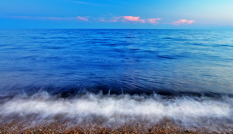 This photograph was taken at a small pebble beach on the south coast of the British Isles. The rich blue tones of the water, and the delicate pink clouds work really well together. Photo: <a href=\"https://www.jordanweeks.com/\" target=_blank>Jordan Weeks</a>
