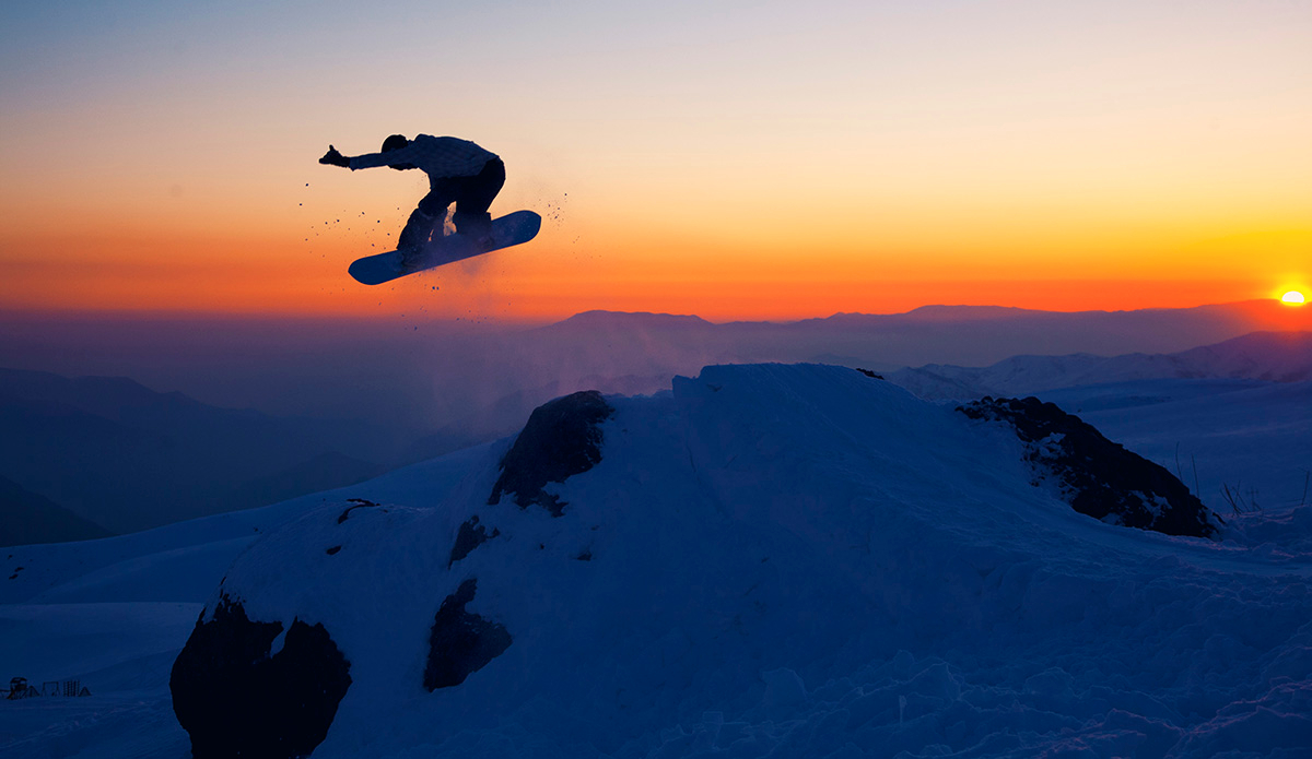 Travis Parker poking out a method off a rock over an incredible sunset in La Parva, Chile.  Photo: <a href=\"https://lauraaustin.4ormat.com/\">Laura Austin</a>