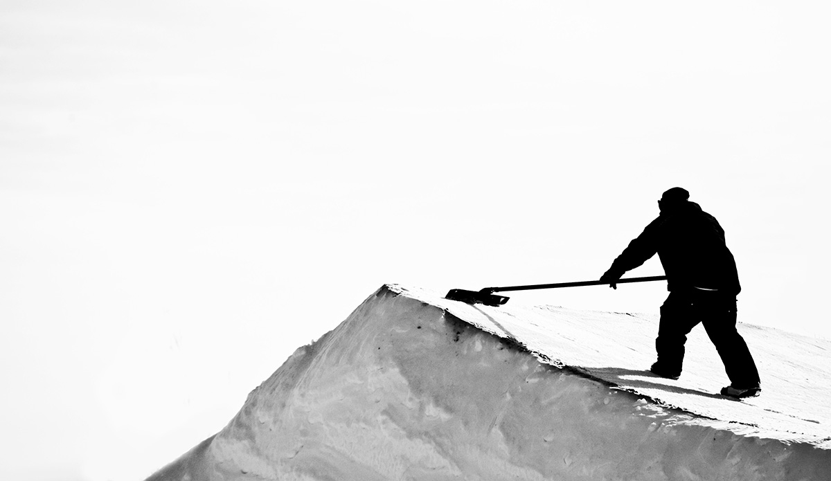 A quiet moment at a snowboard contest as the park staff keeps the jumps in proper condition. Photo: <a href=\"https://lauraaustin.4ormat.com/\">Laura Austin</a>