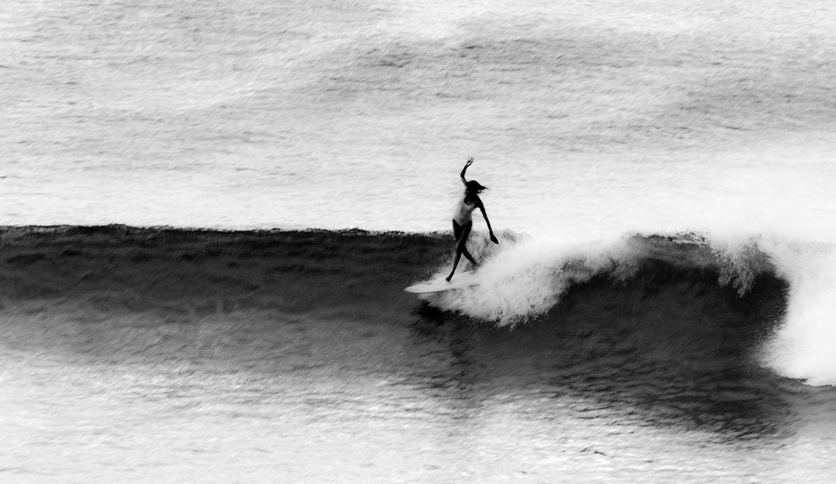 Victoria Vergara—Kirra, Australia. When people refer to Victoria, it is easy to get caught up only in the model looks. There always seems to be a preconceived judgement of character when dealing with the so-called genetically blessed. When I took this photo, we were late into an unusually cold and rainy summer evening. Most people would have called time on this session well before the fading light turned to darkness. This photo is a true juxtaposition of Victoria in many aspects. Visually, her long and graceful body contrasting the desperate move to the nose. Contextually, the stormy and less than ideal conditions contrasting her professionalism in ensuring she got the shot. Victoria came out of the water shaking and cold, but face ablaze and smiling from the pure joy of surf. Positive human. Photo: <a>Fran Miller</a>