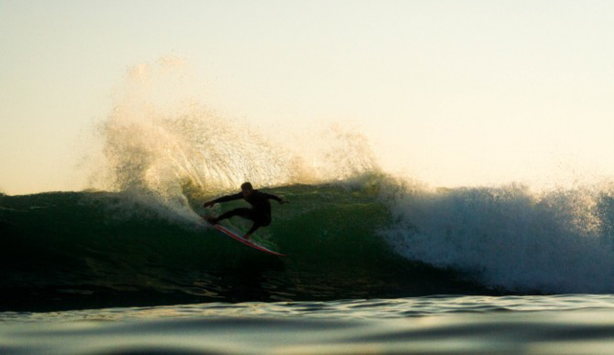 An unknown surfer spraying some golden water around.