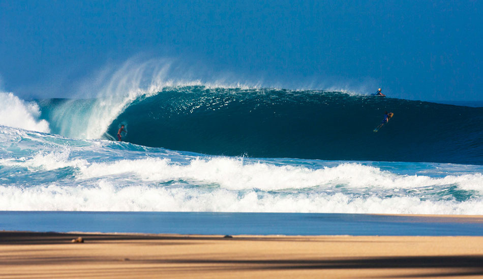 Mark Healey, Pipe. This was from a few years ago now, maybe 2011, I think. This is the biggest and best Pipe I\'ve seen. It was as big as it could handle, actually it was a little too big for most of the morning, but there were some gems that would come in every now and then. Healey, who was obviously sitting deeper than most and dodging the wash-throughs like the madman he is, managed to get most of the best waves. I like the layers that you get from this angle in the early morning. The rich blues are offset by the golden sands and patchy shadows. Photo: <a href=\"https://www.lukeshadbolt.com/\">Luke Shadbolt</a>