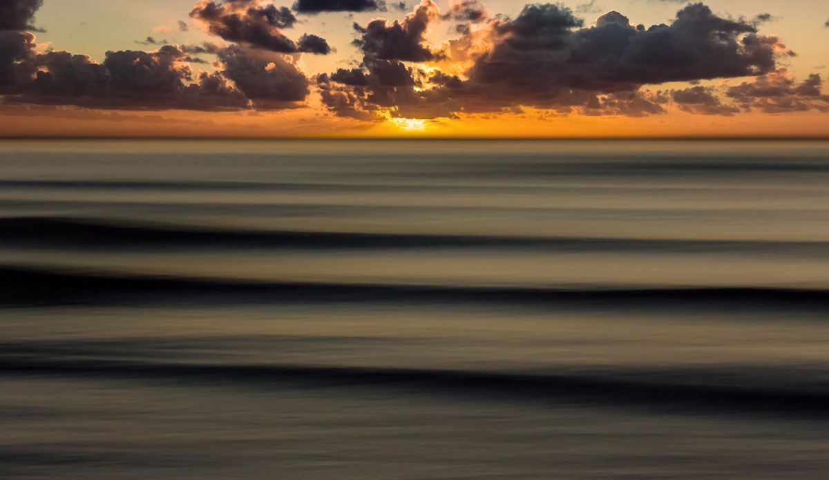 Long set lines roll in during a spectacular sunset. Photo: <a href=\"https://www.mattadenphotography.com\">Matt Aden</a>