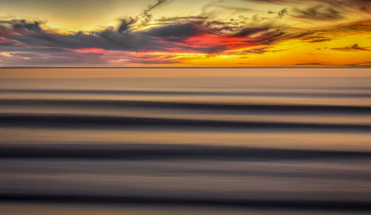 Set lines rolling in at sunset. Photo: <a href=\"https://www.mattadenphotography.com\">Matt Aden</a>