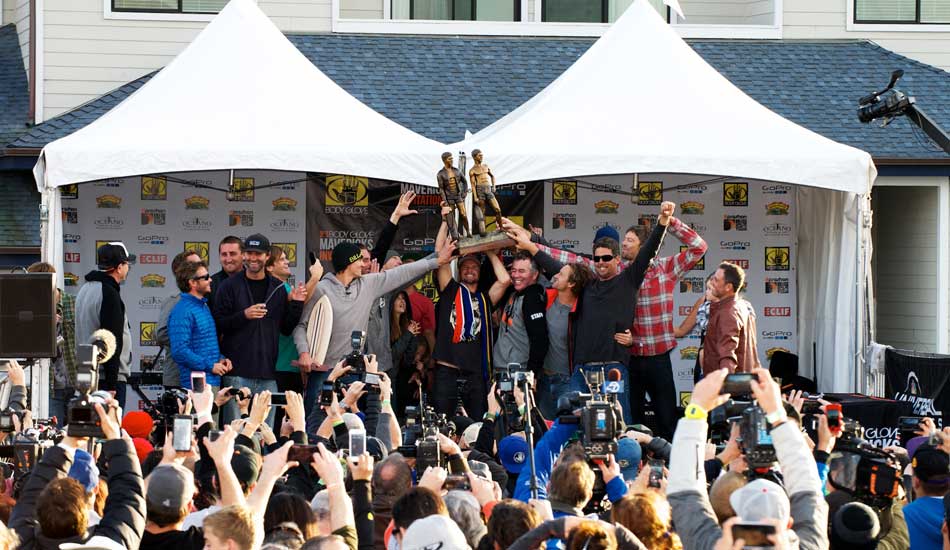 The finalists of the 2014 Maverick\'s Invitational help Grant \"Twiggy\" Baker lift the heavy, custom carved trophy commemorating the co-founders of Body Glove at the awards ceremony in Half Moon Bay, California. Photo: <a href=\"https://www.driftwoodfoto.com/\">Benjamin Ginsberg</a>