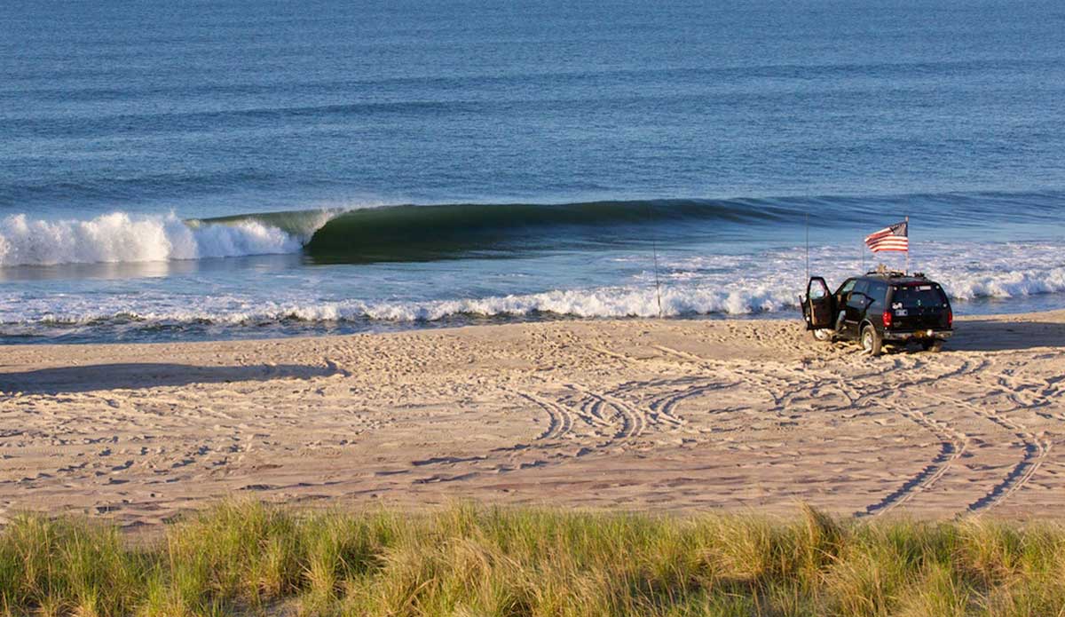 This location is one of the best places to shoot from land that I have found in the NY/NJ area.  This spot is on Long Island and it’s only accessible by driving the beach or walking over a mile if you are up to it.  It’s got really elevated dunes, plenty of trucks to put in the frame, and tons of lefts rolling through.  What more can you ask for? Photo: <a href=\"https://www.mgvphotography.com/\">Michael Vericker</a>