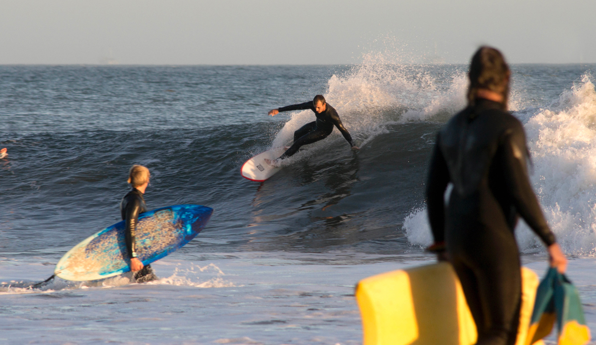 Travers Adler cutting back to the barrel as fellow pit seekers trudge back up the point. Photo: <a href=\"https://www.milesjackler.com\"MilesJackler.com</a>