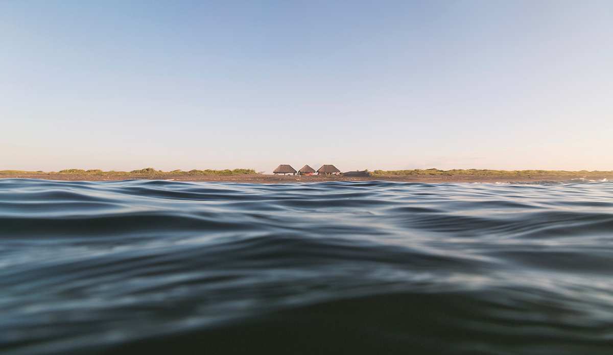 A sight of the shore on a quiet sunny day in the Pacific coast. Just a couple of lonely “ranchos” and the sea. Photo: <a href=\"https://www.kheperphoto.com/\">Paola Núñez Linares</a>