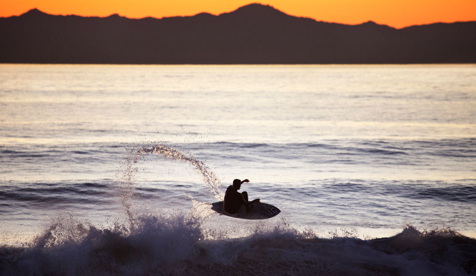 An unknown surfer silhouetted against the evening light in Ventura, CA. Photo: <a href=\"https://paulgreenephoto.com/\" target=_blank>Paul Greene</a> 