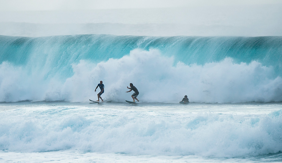 Kelly Slater, on the left, came screaming out of this barrel to meet the two on the right as they exited their wave. Photo: <a href=\"https://www.joliphotos.com/\">Peter Joli Wilson</a>