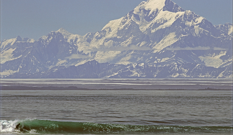 This is my friend Terry surfing the only sunny day we saw on this trip. We camped near here for weeks and never knew the mountain existed until the clouds clear, a truly awe inspiring sight. And that wave is more than just the icing on the cake, long rippable little wave. Image: <a href=\"https://www.paulferraris.com/\" target=\"_blank\">Ferraris</a>