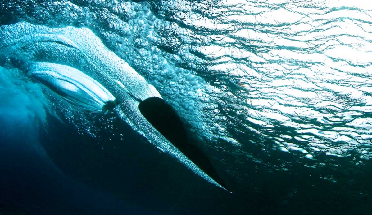 Asher Pacey finger tip control on his Alaia. AP is one of those guys who can transition between boards seamlessly. On this day he must have ridden 5 or 6 totally different boards, from Single fins to no fins and there was not even the slightest “first wave wobble”, it’s like he has already mentally adjusted his surfing to the craft before he stands up. Photo: <a href=\"https://richardkotchphotography.com/\">Richard Kotch</a>