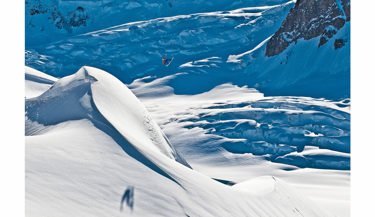 I helped shovel this jump in the clouds for an entire day without knowing what it looked like. The sun broke one afternoon so we headed back to the zone. It wasn\'t until I rode over to the side to shoot that I realized the size of this gap. Travis Rice, Alaska. Photo: <a href=\"https://scottserfas.com/\">Scott Serfas</a>