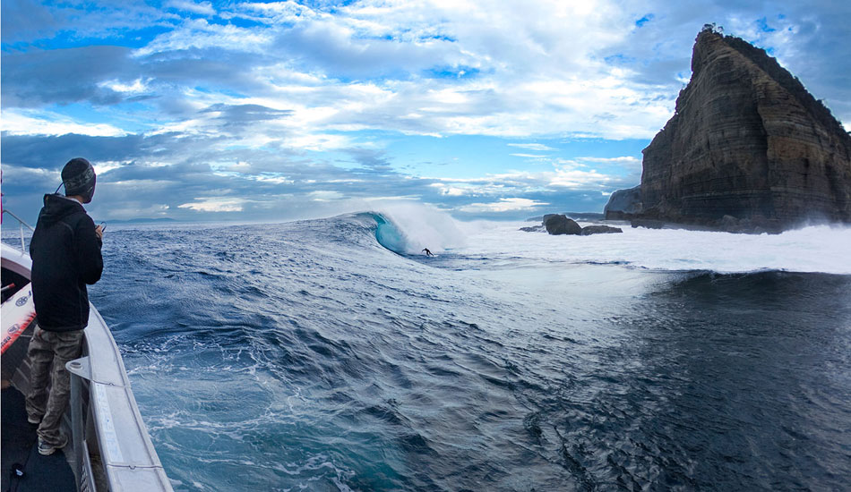 Often the best and most brutal looking slab waves are located in the most incredibly beautiful  places. Shipsterns Bluff in Tasmania is no exception.  180 of the 360 degrees are flanked by huge seaside mountains, of which Shipsterns is one of.  Sitting in the boat this one morning, reminded me so strongly of why it\'s so important to not be just focused on tight action photos. It\'s good to try to capture the experience from a more pulled back perspective.  Photo: <a href=\"https://seandavey.com//\" target=_blank>Sean Davey</a>