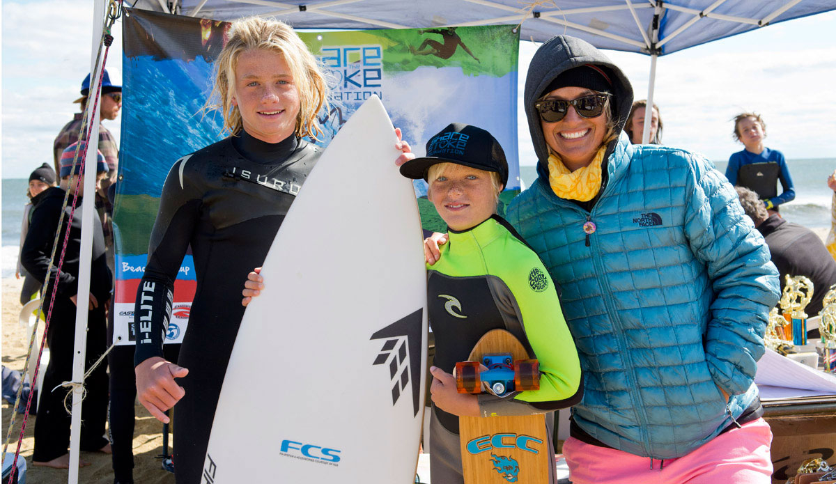 Logan Kamen, event organizer, and Kelly Kingston, Share the Stoke founder, with local grom Matt Voltaggio and his new Firewire and East Coast Customs skateboard. 