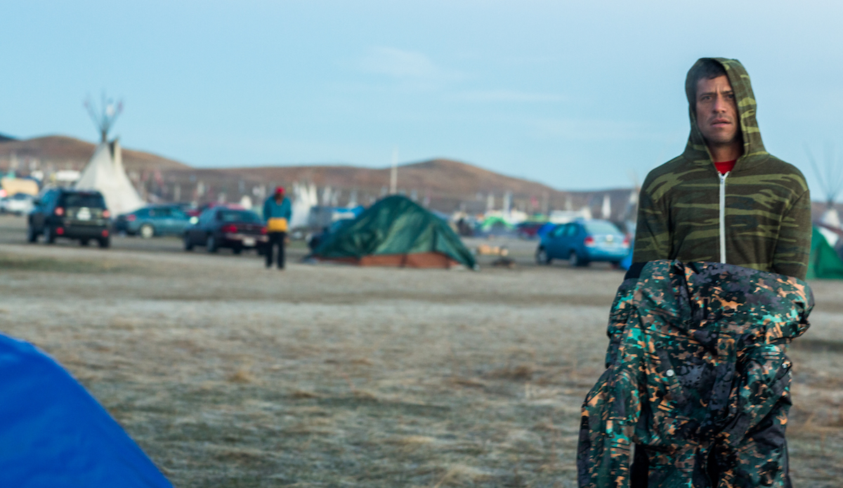 As non-natives, we came in solidarity, but with a respect for the historical division between us and Native Americans. Kamalei Alexander, pro surfer from Kauai who has recently relocated to Oahu, in considerable awe of the grounds. Hawaiians too have a history that runs deep with invasion of their land, taking of their resources and disrespect for their human rights. Photo: Keegan Gibbs