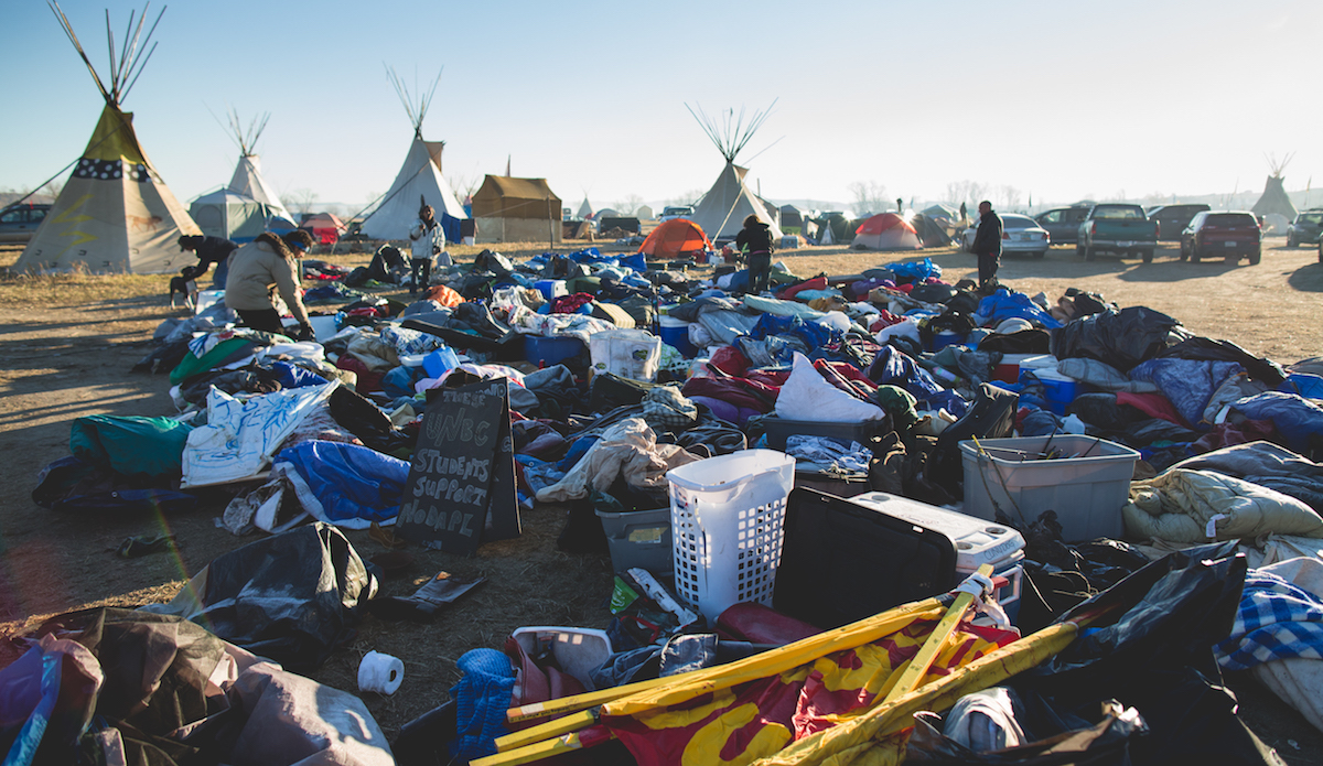What looks like a pile of trash is actually the remnants of the north camp, where police with SWAT gear unexpectedly came in just days before and pulled everyone out of their tents against their will, slashed all their belongings with knives, and dumped the belongings on the side of the road. Photo: Keegan Gibbs
