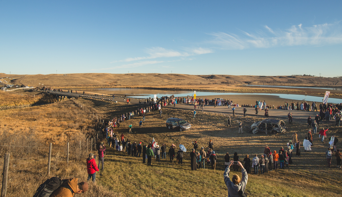 People gathering above the bridge that separates the camp ground and the construction site. Photo: Keegan Gibbs