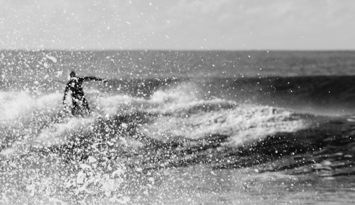 Glimpse. An unknown surfer attempts to avoid getting himself in the frame from an unexpected burst of water. Photo: <a href=\"https://rickycavarra.com\">Ricky Cavarra</a>